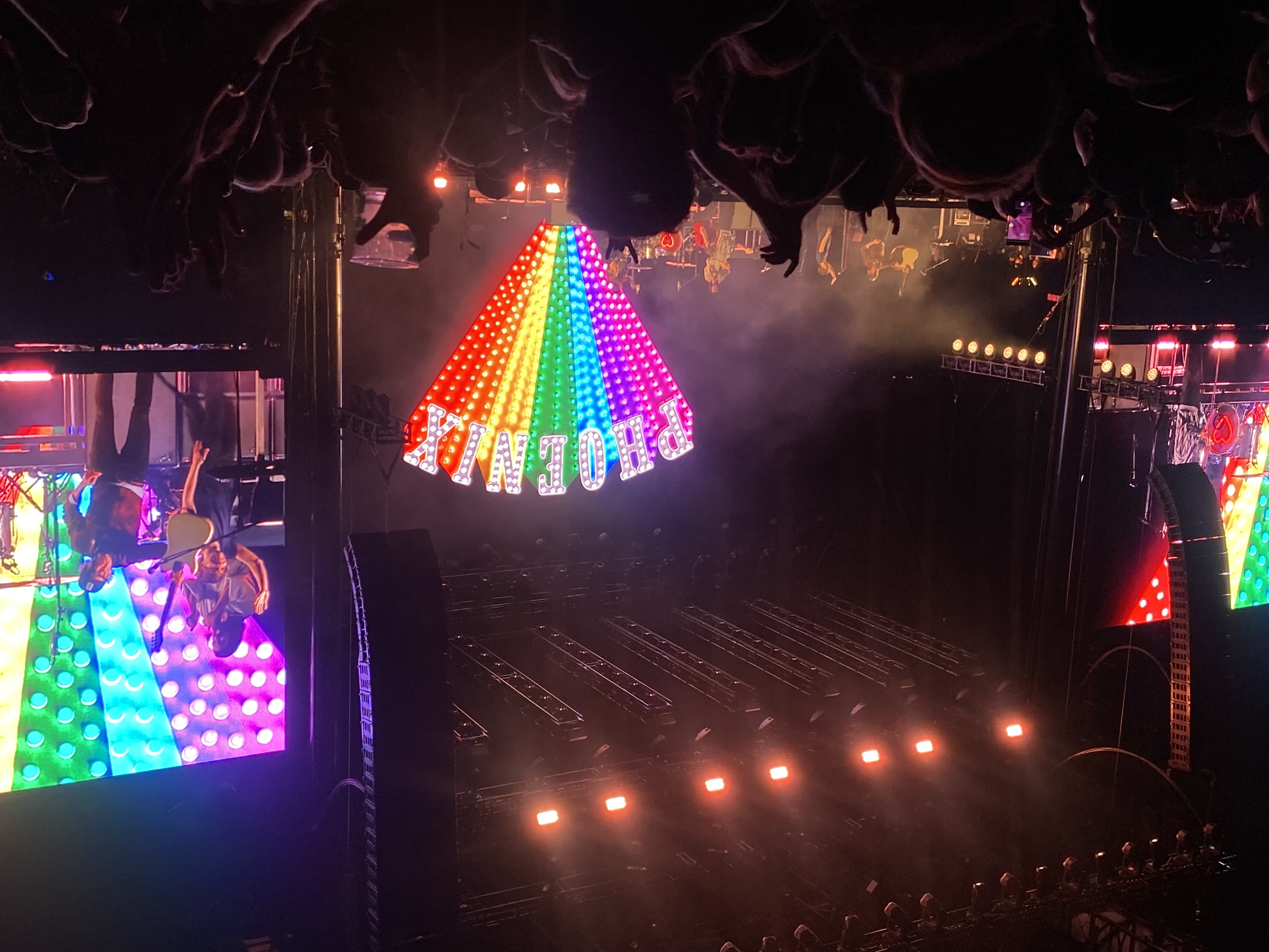 Phoenix concert with colorful rainbow LED sign and stage lights