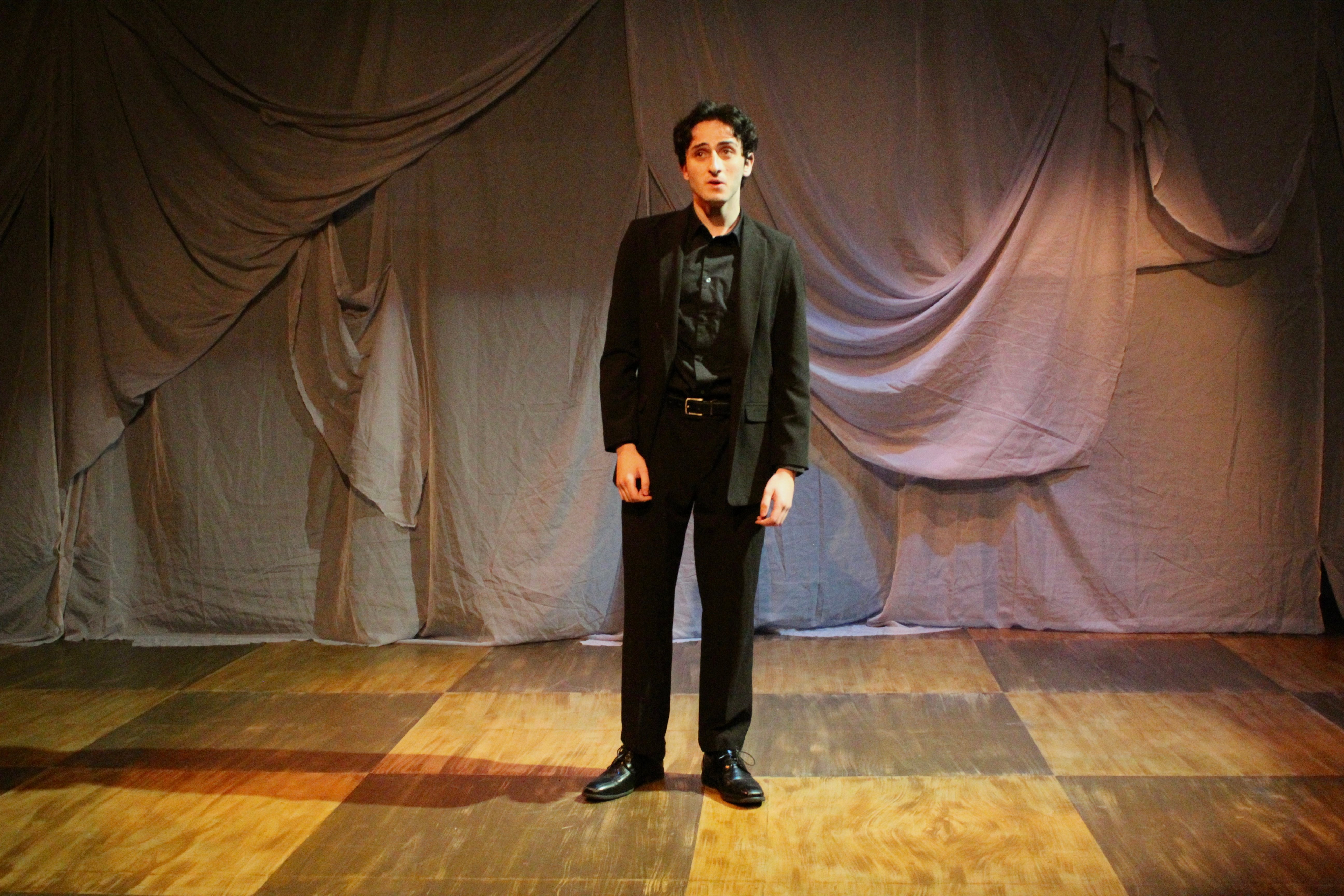 Falsettos - Man in black suit solo on checkered floor