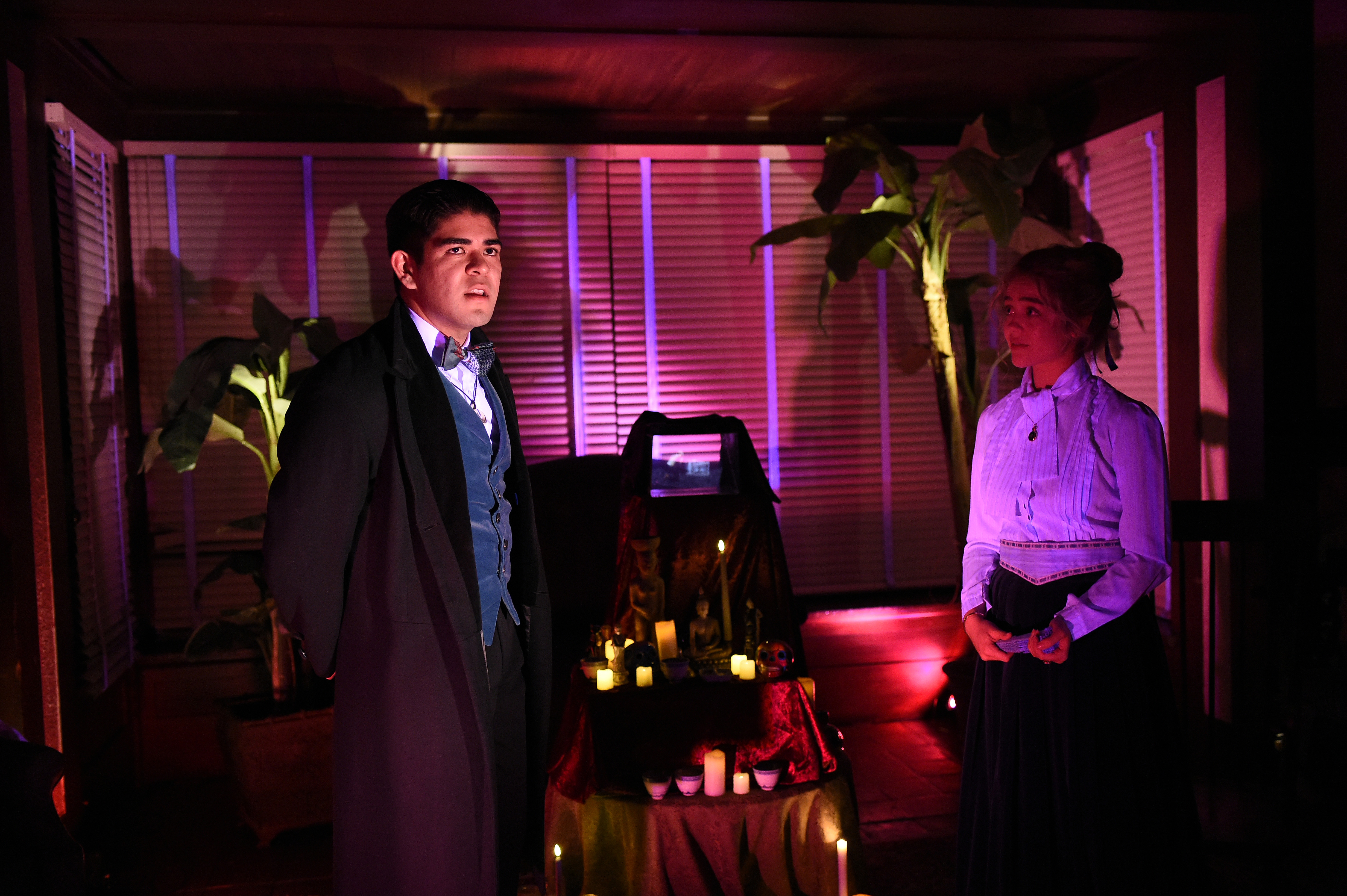 Ghosts of USC - Man and woman by candlelit altar with magenta lighting