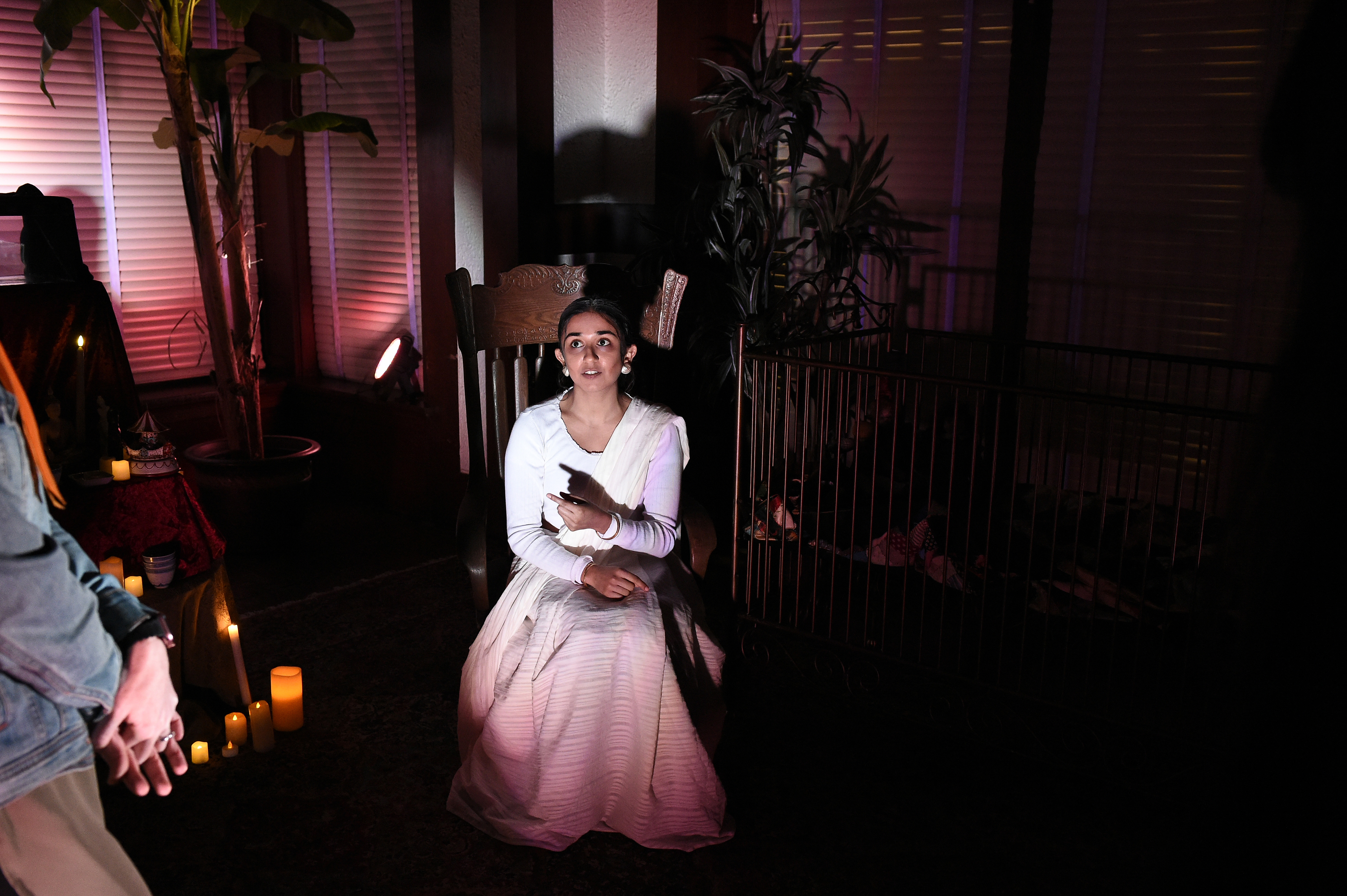 Ghosts of USC - Woman in white seated with candles, pink lighting