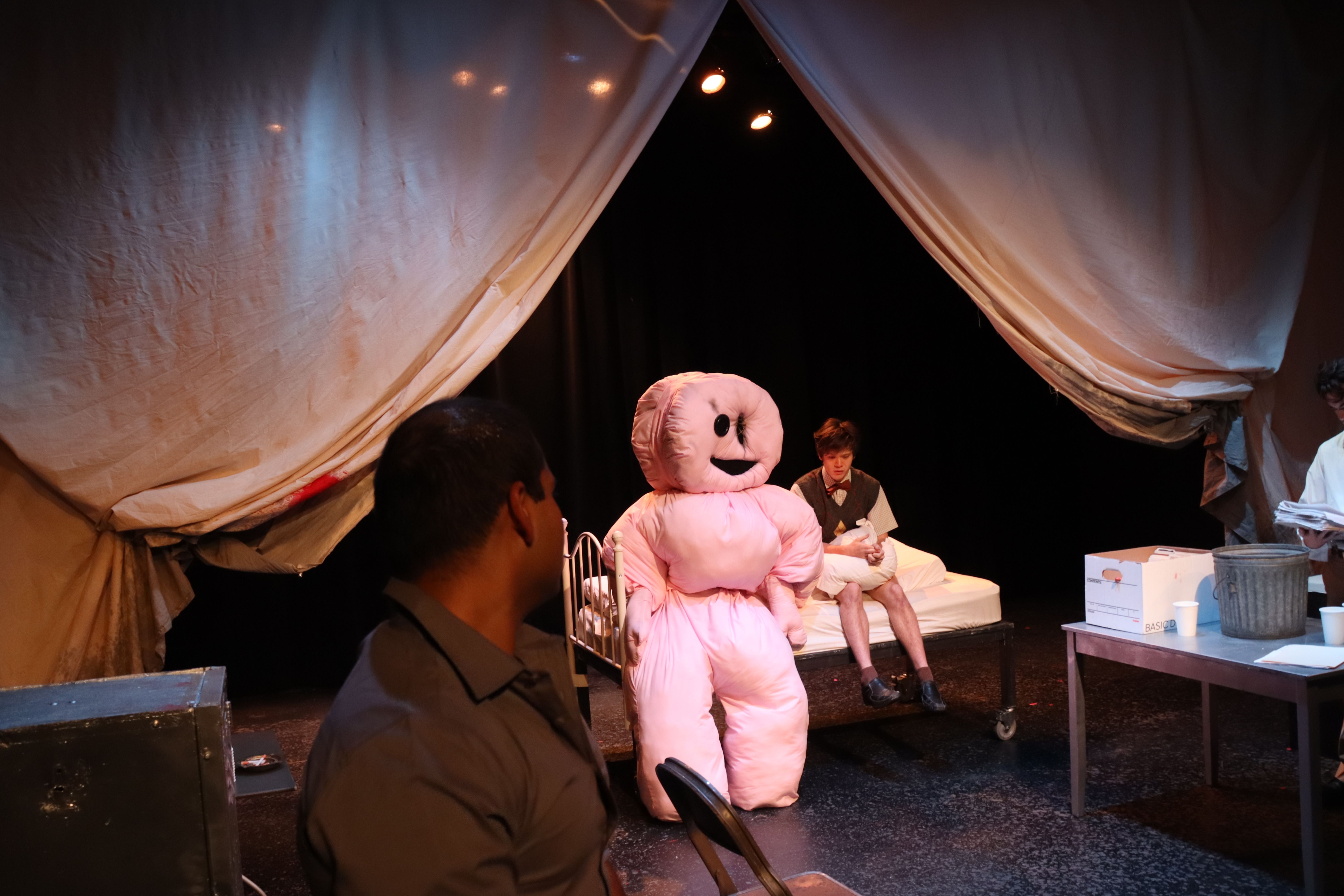 The Pillowman - Surreal scene with pink inflatable figure