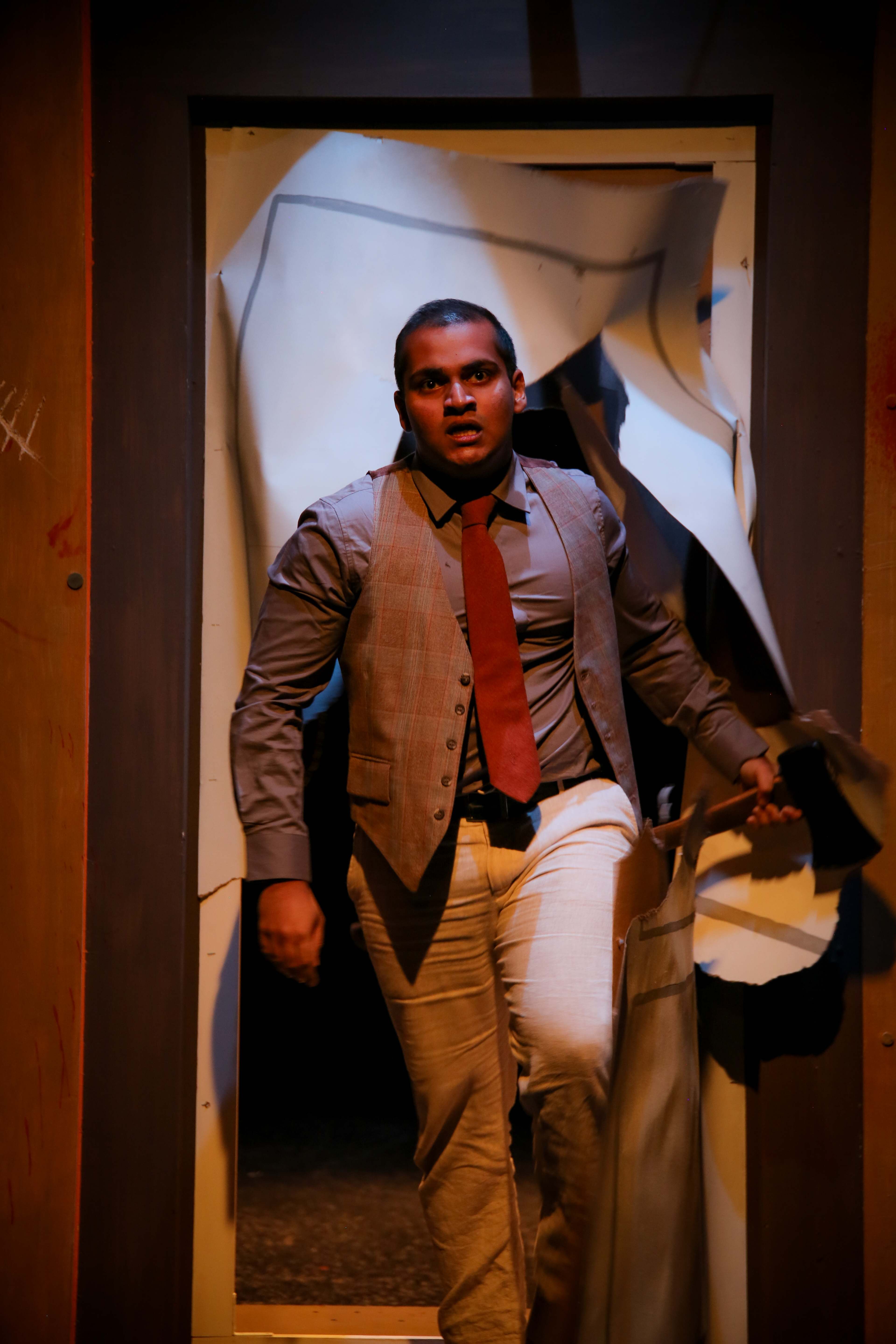 The Pillowman - Man bursting through torn paper doorway