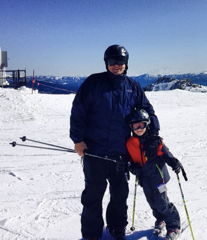 Father and son skiing with Lake Tahoe views