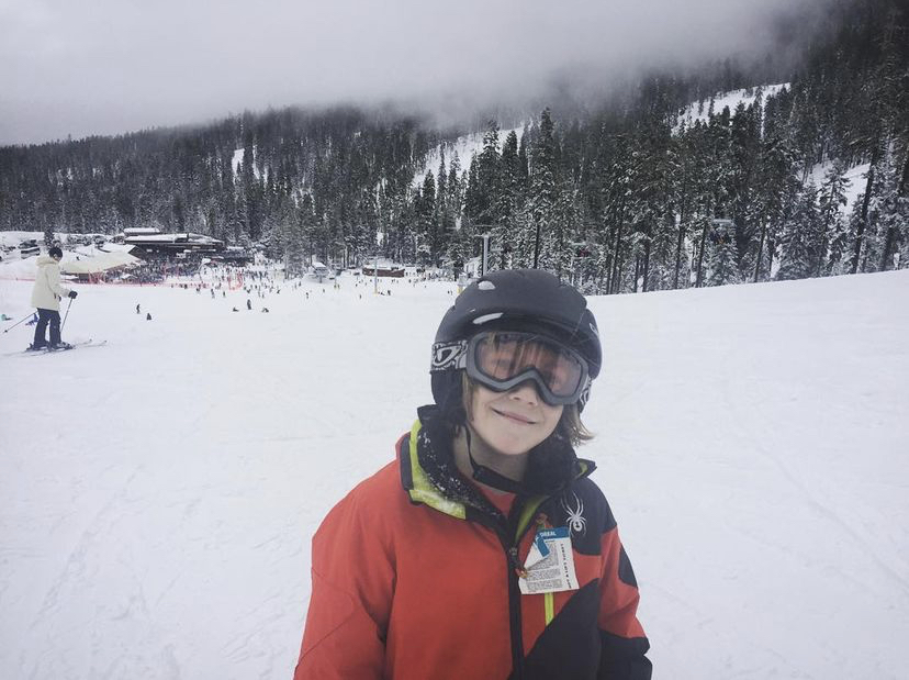 Young skier in red Spyder jacket at foggy resort base