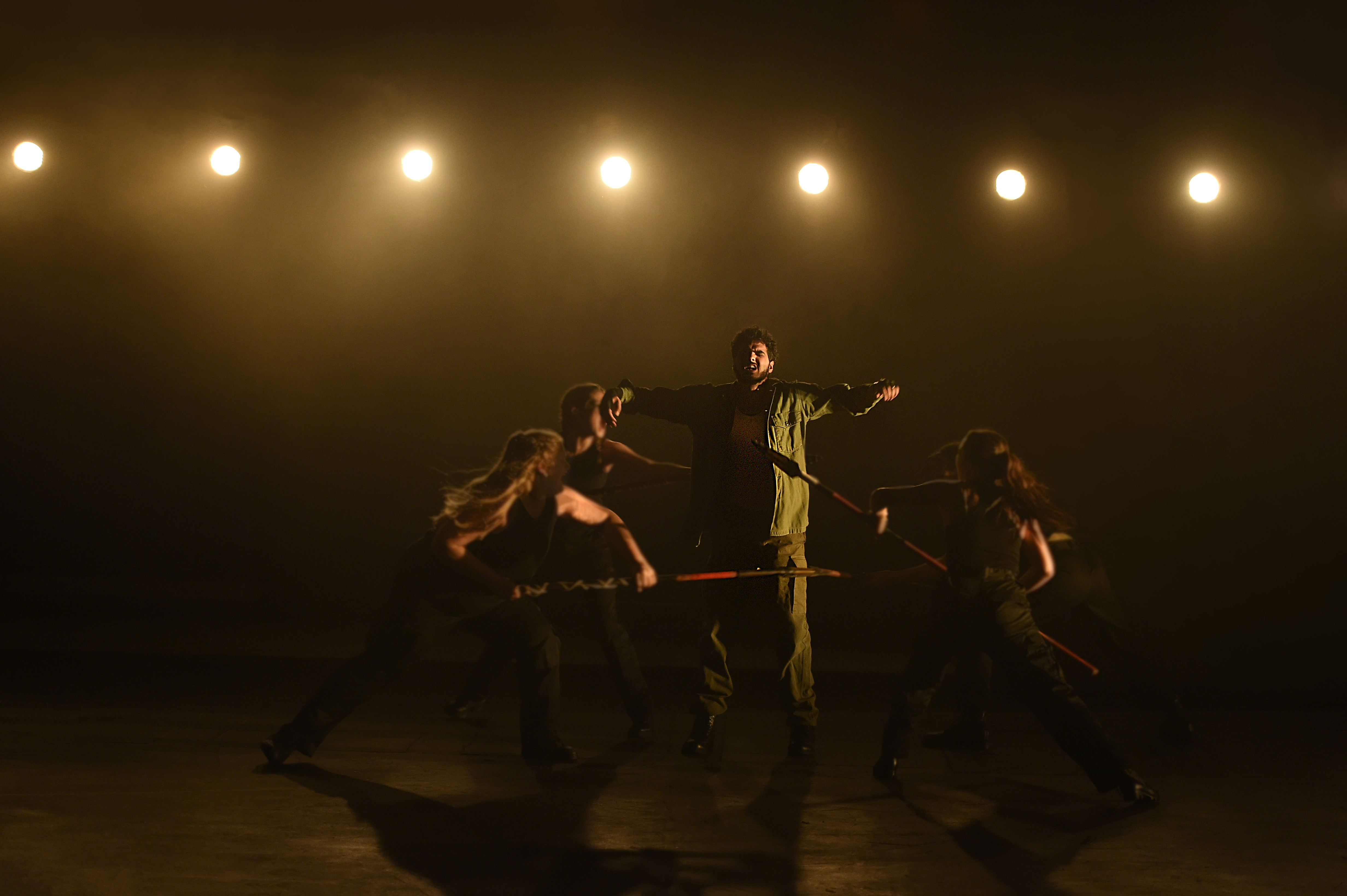 Troilus and Cressida - Actor with arms outstretched under row of lights