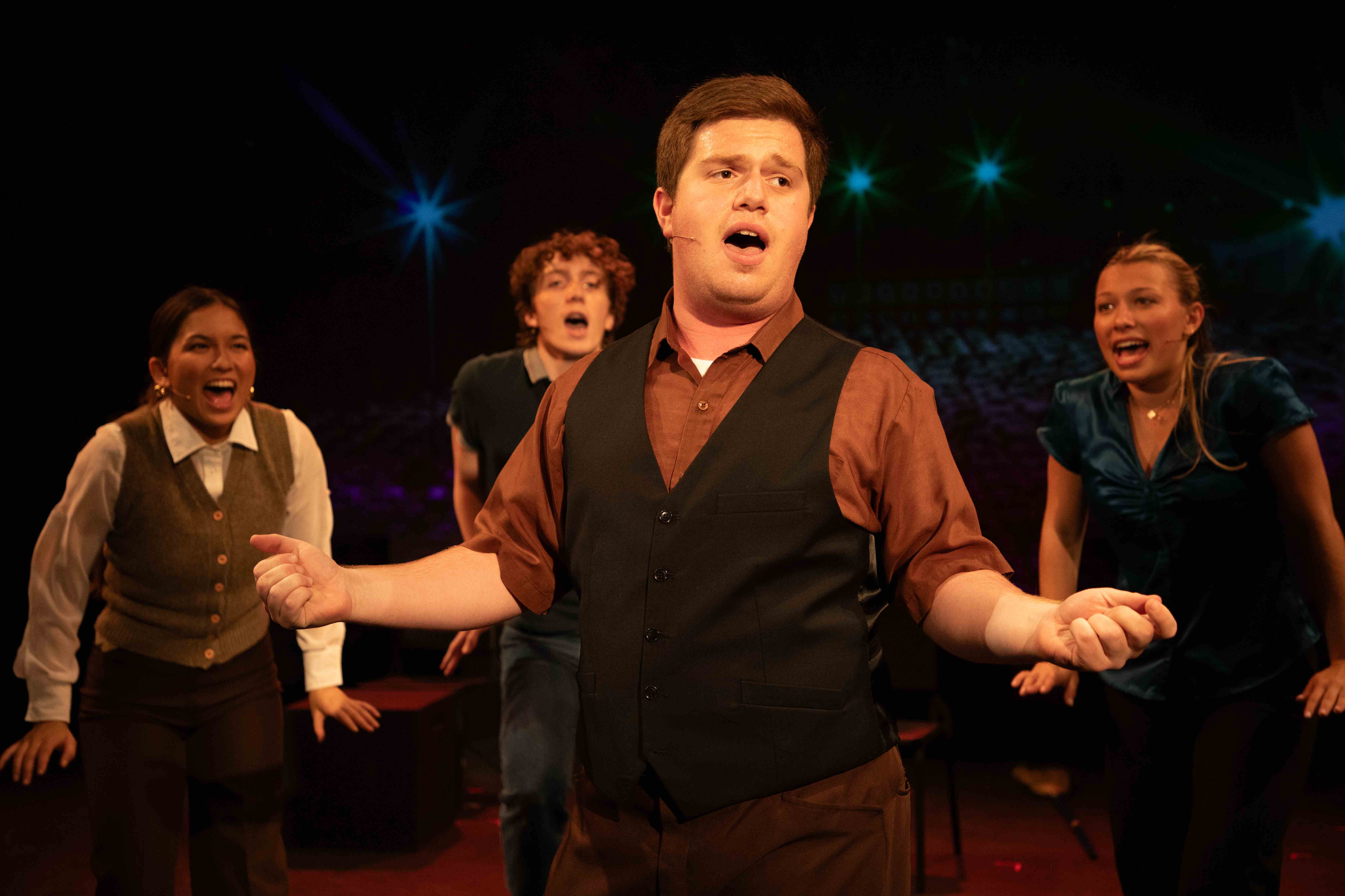 Working - Ensemble number with man in vest singing center stage