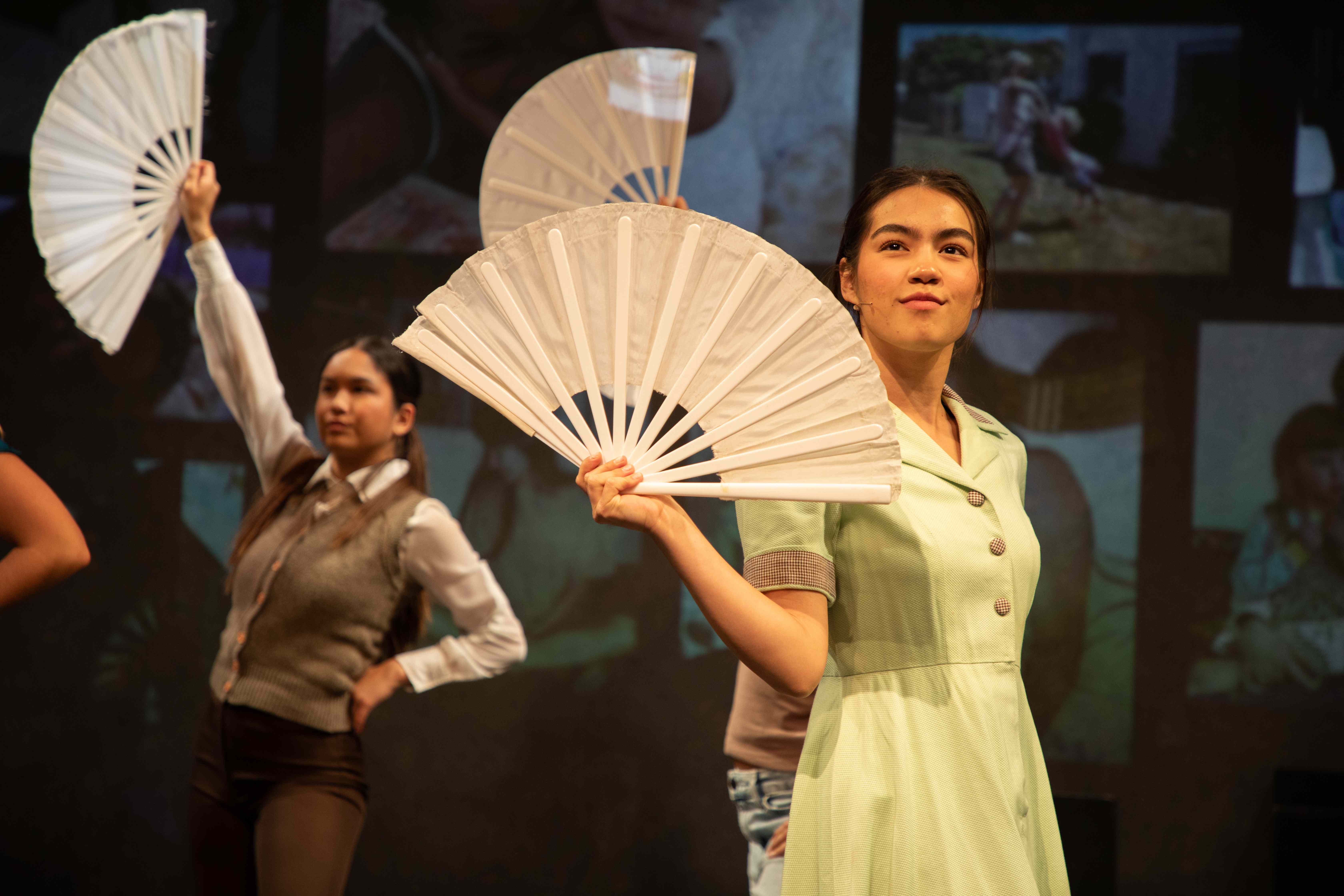 Working - Waitresses in period costumes with white paper fans